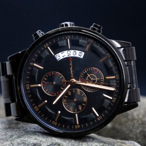 Close-up of a stylish black chronograph wristwatch showcasing its intricate dial design.